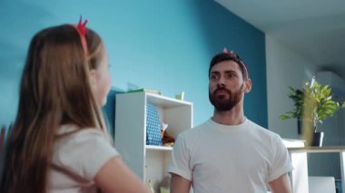 Prenses gibi giyinmiş, kızının evde balerin gibi dans etmesinden sonra gülümseyen komik baba portresi. Şık kostüm partisi.