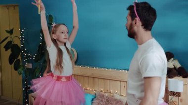 Güzel kız ve babasının evde balerinler gibi dans edişlerinin yan görüntüsü. Kostüm partisi, eğlence zamanı..