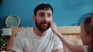 Peri partisi için giyinmiş zavallı bir babanın portresi. Yakından bakınca tatlı kız babasının yüzüne makyaj pudrası sürüp onu kutlamaya hazırlıyor..