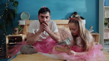 Babayla kızı evde güzel bir parti vermek için kavga ediyorlar. Makyaj beklerken ağzını kapatan yakışıklı bir adamın portresi. Küçük kız babasının yüzüne makyaj yapıyor. Yatakta oturuyor..