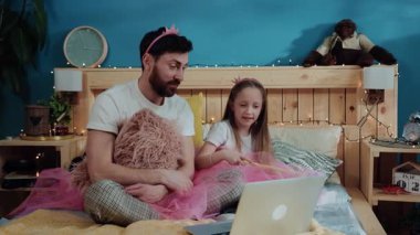 Baba ve kız periler birlikte çizgi film izliyorlar. Mutlu baba ve kız sihirli değnekle oynuyorlar evde kostüm partisinde eğleniyorlar..