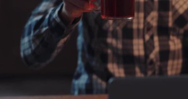 Üretkenlik için ahşap bir masada, parlak bir dizüstü bilgisayarın yanında ferahlatıcı bir içecekle rahat bir çalışma alanı hayal et.