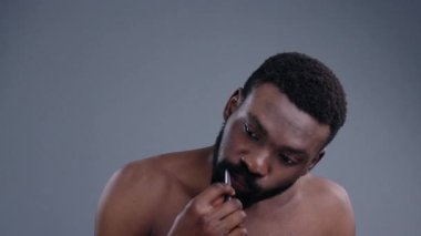 Siyah arka planda diş fırçasıyla dişlerini fırçalayan çekici Afrikalı genç bir adam. Banyoda güne hazırlanan meşgul siyahi adamın portresi..