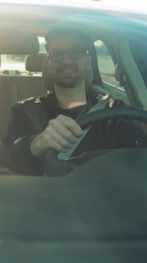 Şık güneş gözlüklü, kendine güveni ve maceraperest ruhu simgeleyen sakin bir yolculuğun tadını çıkaran bir adam.