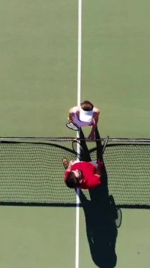 Büyüleyici bir tenis sahnesi. Parlak renkli bir kortta bir oyuncunun gölgesini yakalıyor.