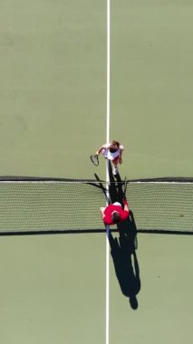 Havadan bakıldığında canlı bir tenis kortu görülüyor. Ağı vurguluyor ve maç için farklı çizgiler çiziliyor.