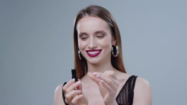 Kendine güvenen bir manken şık bir makyaj ve minimalist bir arkaplana karşı modaya uygun bir kıyafet sergiler.