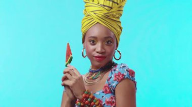 Şık giyinmiş, yaz kıyafetleri içinde sulu bir karpuz şekeri tutan, yaz havası yayan bir kadın.