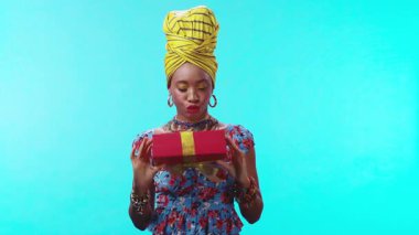 Canlı giyinmiş bir kadın, neşeyle sarılı bir hediye tutar, kültürel kutlama ve mutluluğu somutlaştırır.