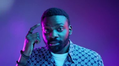 Şık giyinmiş, parlak ve neon ışıklı efektlerle aydınlatılmış bir adamın büyüleyici bir portresi.