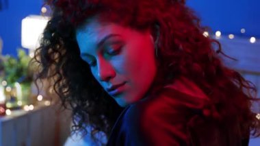 Güzel, şık bir odada renkli ışıkla geliştirilmiş yansıtıcı bir anı yakalayan sanatsal bir çekim.