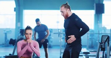 Spor salonunda kadın vücut geliştirici çekici kadın özel antrenörle konuşuyor profesyonel erkek yoğun idman egzersizleri yapıyor birlikte çalışıyoruz. Spor..