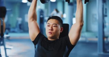 Asyalı vücut geliştirici yakışıklı orta yaşlı adam ağırlık kaldırıyor spor salonunda ağırlık çalışıyor. Aktif sporlar. Sporcu yaşam tarzı.