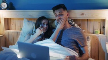 Sevgi dolu bir çift yatakta birbirine sokulur, keyifli bir film gecesi deneyimi için laptoplarını paylaşırlar.