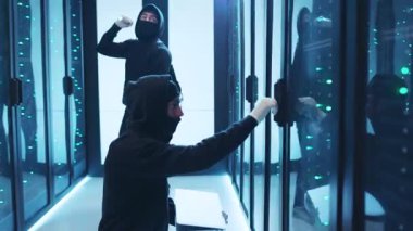 Yüksek güvenlikli bir veri merkezinde maskeli kişilerin şüpheli faaliyetlerde bulunduğu gizli bir operasyon.