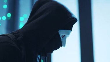 Çevresindeki mavi ışıklarla çevrili bir maske takan gizem ve entrika dolu bir atmosfer yaratıyor.