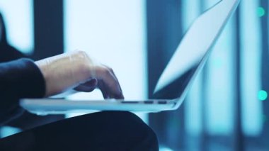 Çağdaş bir çalışma alanı içinde modern bir dizüstü bilgisayarda aktif olarak yazı yazan birini gösteren detaylı bir yakın çekim resmi