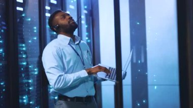 Odaklanmış bir adam yüksek teknoloji sunucu odasında çalışır, bilgisayarını sistemleri izlemek için kullanır. Sahne, onun çeşitli pozisyonlardaki bağlılığını gösteriyor.