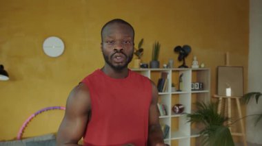 Bu videoda, rahat bir oturma odasında bir adam telefonuna dalmışken hulahop tutuyor, dinginlik anlarını oyunla harmanlıyor.