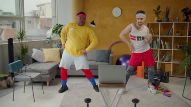 Bu canlı video, iki adamın sıcak bir oturma odasında neşeyle dans ettiğini, kahkaha ve enerjiyi paylaştığını, canlı bir arkadaşlık ortamı yarattığını gösteriyor.