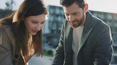 Göl kenarında bebek arabası olan sevimli bir aile standı. Anne ve baba yeni doğmuş bebekle oynuyorlar. Gülümseyen mutlu hisseder. Ebeveynlik. Yavaş çekim