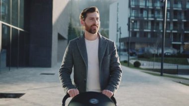 Göl kenarında bebek arabasıyla yürüyen yakışıklı bir adam. Babam bahar gününün tadını çıkarıyor. Ebeveynlik. Yavaş çekim.