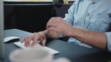 Yakın plan bir resim, modern ve verimli bir çalışma alanı atmosferini vurgulayarak, aktif olarak bir klavyeye yazı yazan elleri betimler