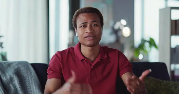 Çevrimiçi konferans veren yakışıklı ve zeki bir Afrikalı 'nın video portresi. Kameraya bakıp açıklama yapıyor ve öğretiyor. Video konferansı. İşadamı.