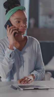 Bu videoda masa ve masada oturan bir kadın var. Telefonunu kontrol edip sohbet ediyor. İfadelerini ve modern bağlantılarını vurguluyor.