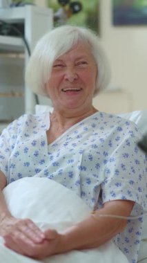 Torunuyla birlikte neşeli bir son sınıf öğrencisi. Tablet sohbeti yapıyor. Hastane odasında kahkahalarla gülüyor. Komik aile. Aile desteği. Kadın bir hasta. Sağlık Hizmetleri.