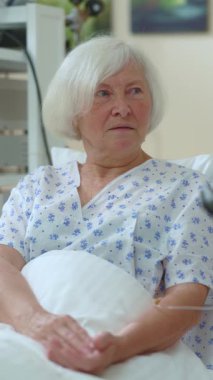 Genç kız, hastane odasında yaşlı annesi ile konuşuyor ve tablet kullanarak iletişim kuruyor. C aucasian ailesi. Destek, ilişkiler. Sağlık Hizmetleri.