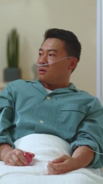 Hasta, sefil Çinli bir adam hastane yatağında kendini kötü hissederek koronavirüs semptomları gösteriyor. İlaç tedavisi. Sağlık sigortası ve hastane. Hastalık kavramı, virüs enfeksiyonları.