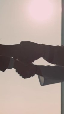 Video, beyaz bir duvarda bir kuşla bağlantı ve özgürlük, diğerine uzanan bir el ve özlemi simgeleyen okyanus günbatımını sergiliyor.
