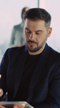 Zarif takım elbiseli kendine güvenen bir adam sıcak bir gülümsemeyle dikkatleri üzerine çeker. Modern bir ofiste, profesyonellik ve karizma yayar.