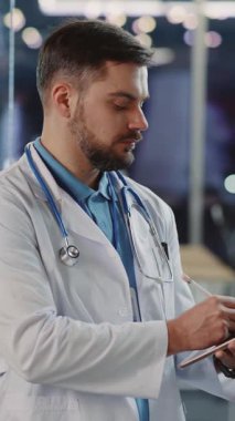 Bu videoda, bir doktor sağlık hizmetlerinde ileri teknoloji kullanır, bir tablet üzerindeki hasta bilgilerini gözden geçirir, tedavinin geliştirilmesinde dijital araçların rolünü gösterir