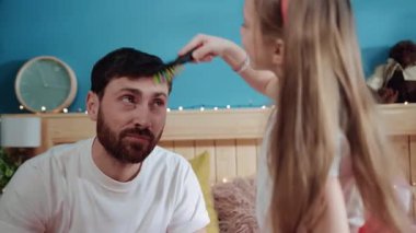 Evdeki kostüm partisi için babasının saçlarını tarayan küçük sevimli kız onu prenses gibi giydiriyor..