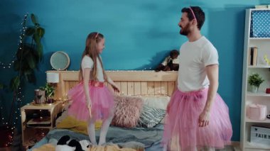 Mutlu insanlar, aile kostüm partisinde prenses gibi giyinmiş baba ve kız. Küçük heyecanlı kız sihirli değnekle el sallıyor ve babasını yatak odasında bir balerine çeviriyor..