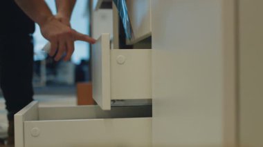 Tadilattan sonra yeni mobilyalar geliyor. Bir çalışan, arkadaşına çekmecelerin nasıl açılıp kapanacağını gösteriyor..