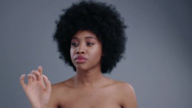 Gri arka planda izole edilmiş teknoloji hologramını kullanarak sanal ekranda gezinen güzel görünümlü Afrikalı Amerikalı kızın portresi..