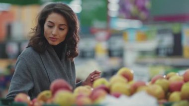 Elma meyvesi seçen genç bir kadın. Sebze sebze süpermarketi. Hayat tarzı, ticaret ürünü.