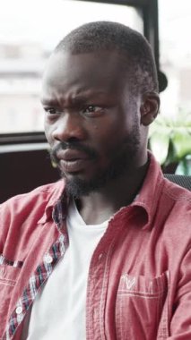 Bir adam yoğun bir şekilde odaklanmış ve konsantrasyonunu parlak, modern bir çalışma ortamında sergiliyor.