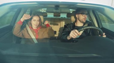 Arabadaki iki kişiyi güzelce yansıtan bir sahne, sürüş sırasında samimiyet, yakınlık ve bağlantıyı yansıtıyor.