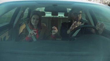 İki yetişkinin olduğu bir arabada neşe ve eğlence dolu hareketli ve dinamik bir arkadaşlık sahnesi.