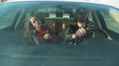 İki neşeli gezgin, ferah bir arabayla keyifli yolculuklarının tadını çıkarıyorlar. Saf mutluluk ve bağları yakalıyorlar.