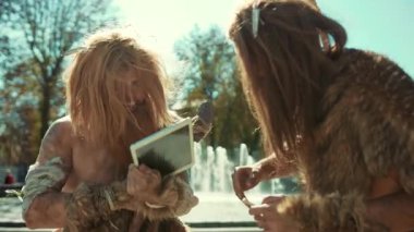 Mağara adamları, kentsel bir çevrede gezinirken modern teknolojiyle eğlenceli yollara başvururlar.