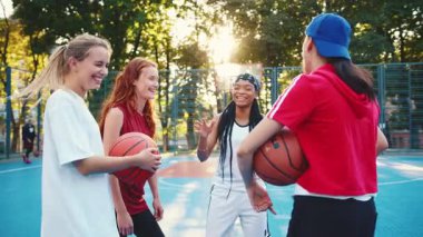 Canlı, coşkulu bir grup kadın gün batımında sahada basketbol hakkında ateşli bir tartışmaya girişiyor.