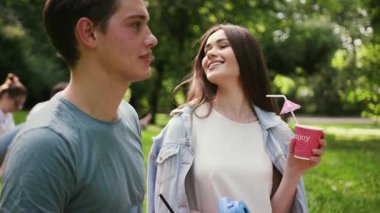 NEW YORK - 5 Nisan 2017: Parkta dinlenen gülümseyen güzel bir çift portresi piknik konuşmaları yapan adam çiçekleri sunan kadın ağaç kızı yaz aşkı doğa güzel açık hava eğlencesi