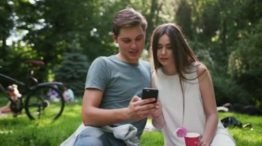 Kapalı portre mutlu genç çift parkta dinleniyor piknik konuşmaları erkek kadın aşk kadını yaz doğası güzel duygusal doğa oldukça yavaş çekim zevk dışarı