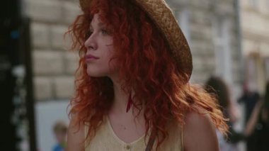 Portre genç, gülümseyen, kızıl saçlı, kameraya bakan, şehirde yürüyen mutlu, yavaş çekim yaz yüzlü, Kafkasyalı, güzel, açık hava bayan portresi. Hoş bir duygu.