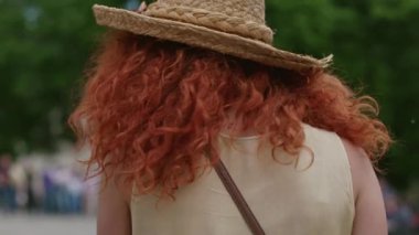 Yüzü kızıl kıvırcık saçlı genç bir kadın kameraya bakıp gülümsüyor. Mutlu bir şekilde sokaklarda yürüyor. Yazın Kafkasya 'nın günbatımında yüzyüze.